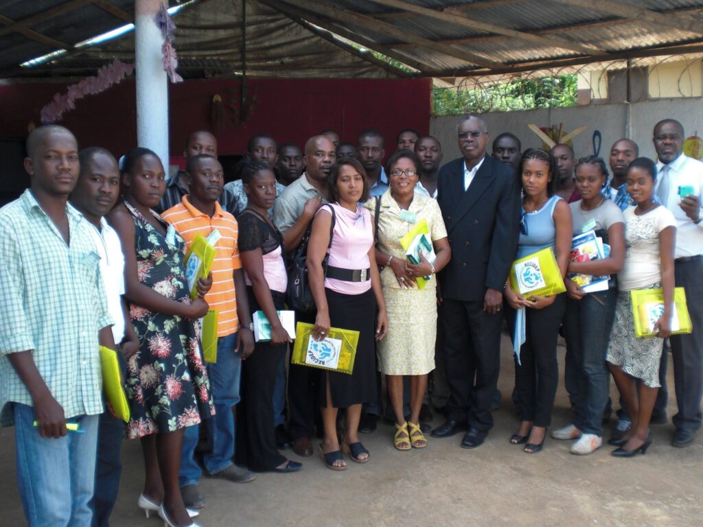 Participants gathered for a group photograph, holding RECIDEP folders and training documents